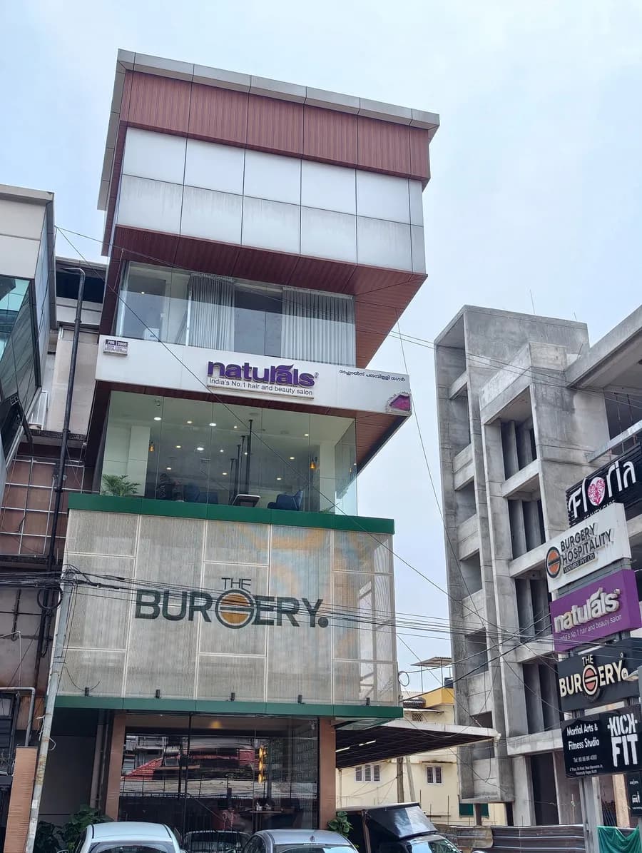 Straight-on view of the building at Kadavanthra with its stone-look ground floor and lettering