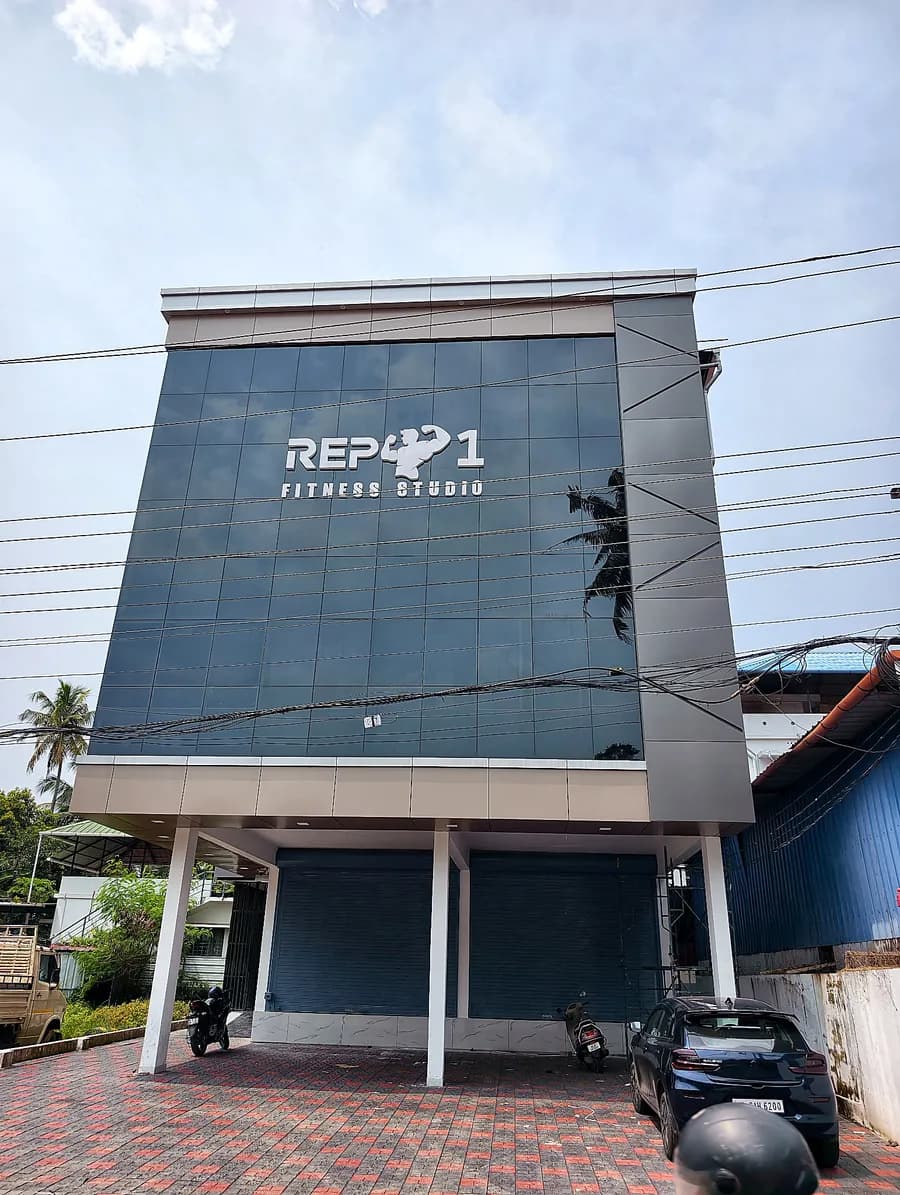 Building at Ayisha Road with a dark glass facade and white logo, seen from the front