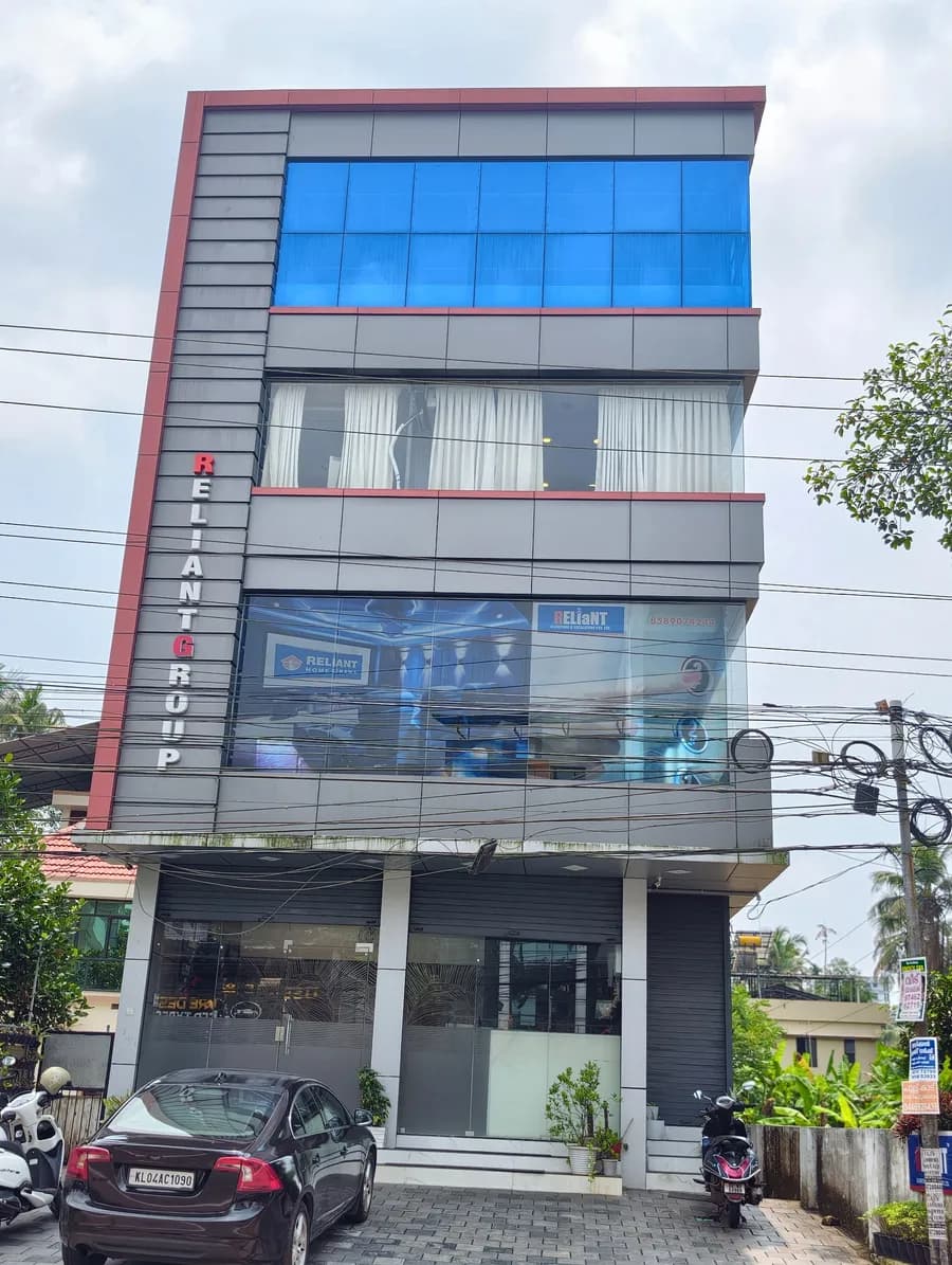 Straight-on view of the building at Maradu with its red-edged grey cladding