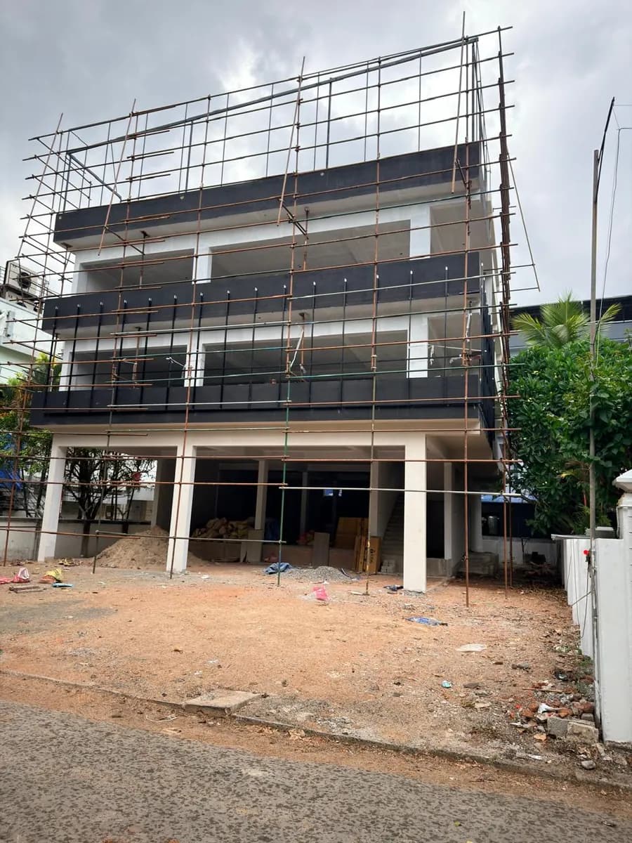 Building with scaffolding on its upper floors and bare ground in front